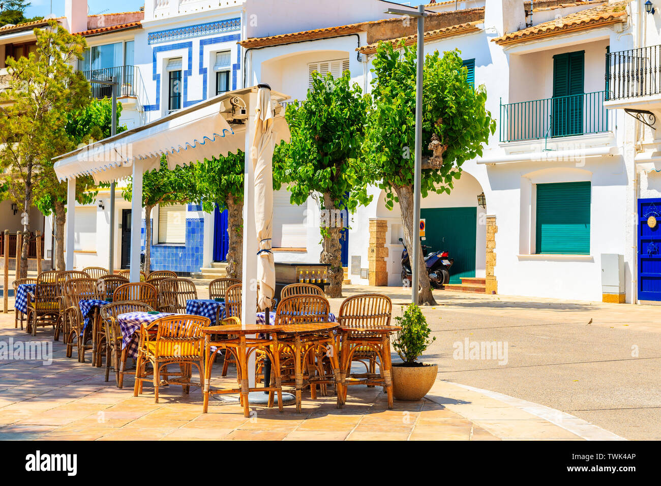 Restaurant tables on street of small fishing village of Llafranc, Costa Brava, Spain Stock Photo