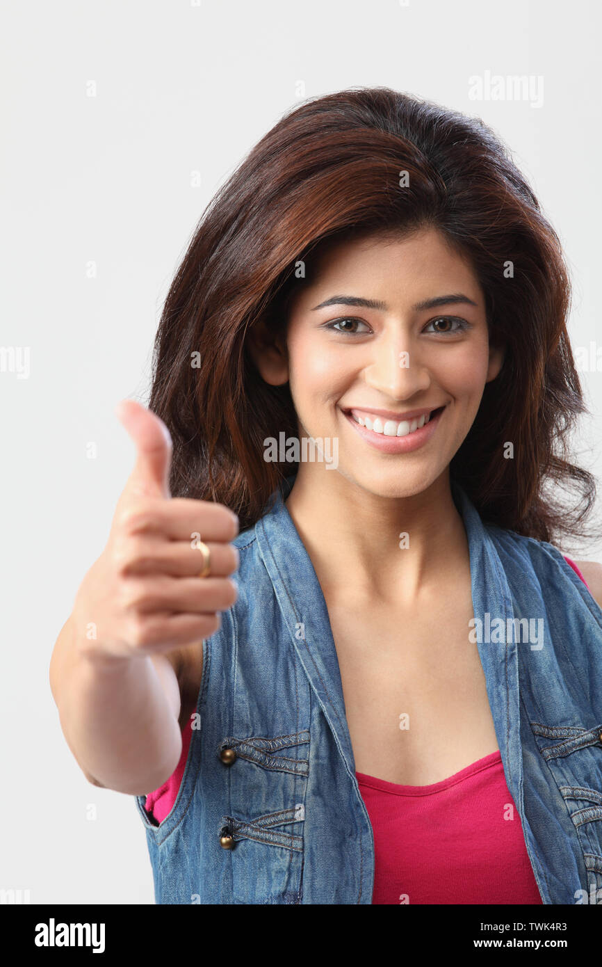 Portrait of a woman showing thumbs up sign and smiling Stock Photo - Alamy
