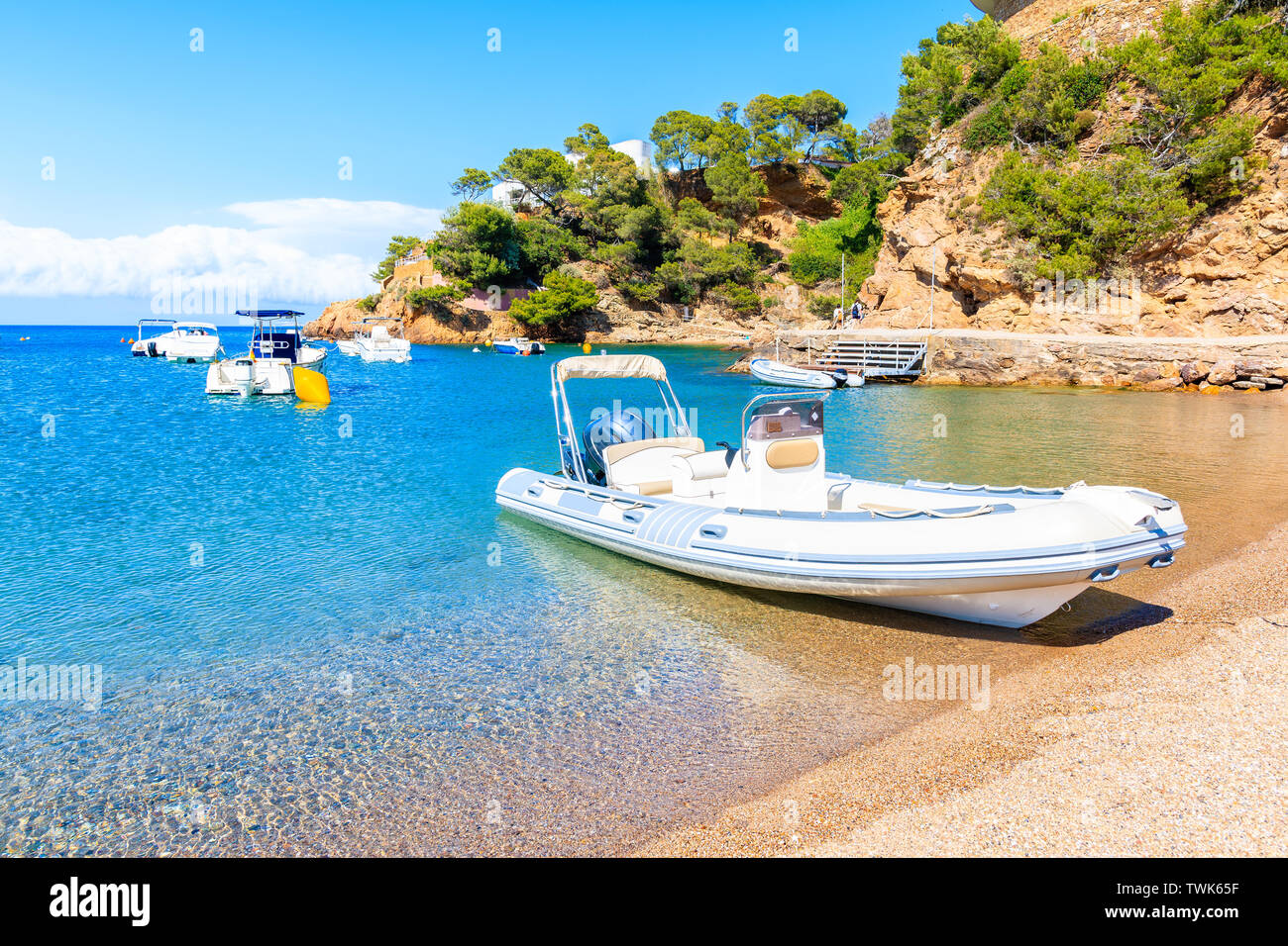 Dinghy boat anchoring at Sa Riera beach in idyllic sea bay, Costa Brava