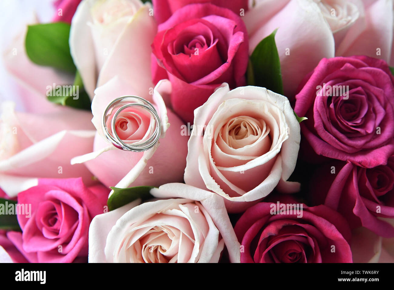 close up wedding ring on top of a pink color bouquet Stock Photo