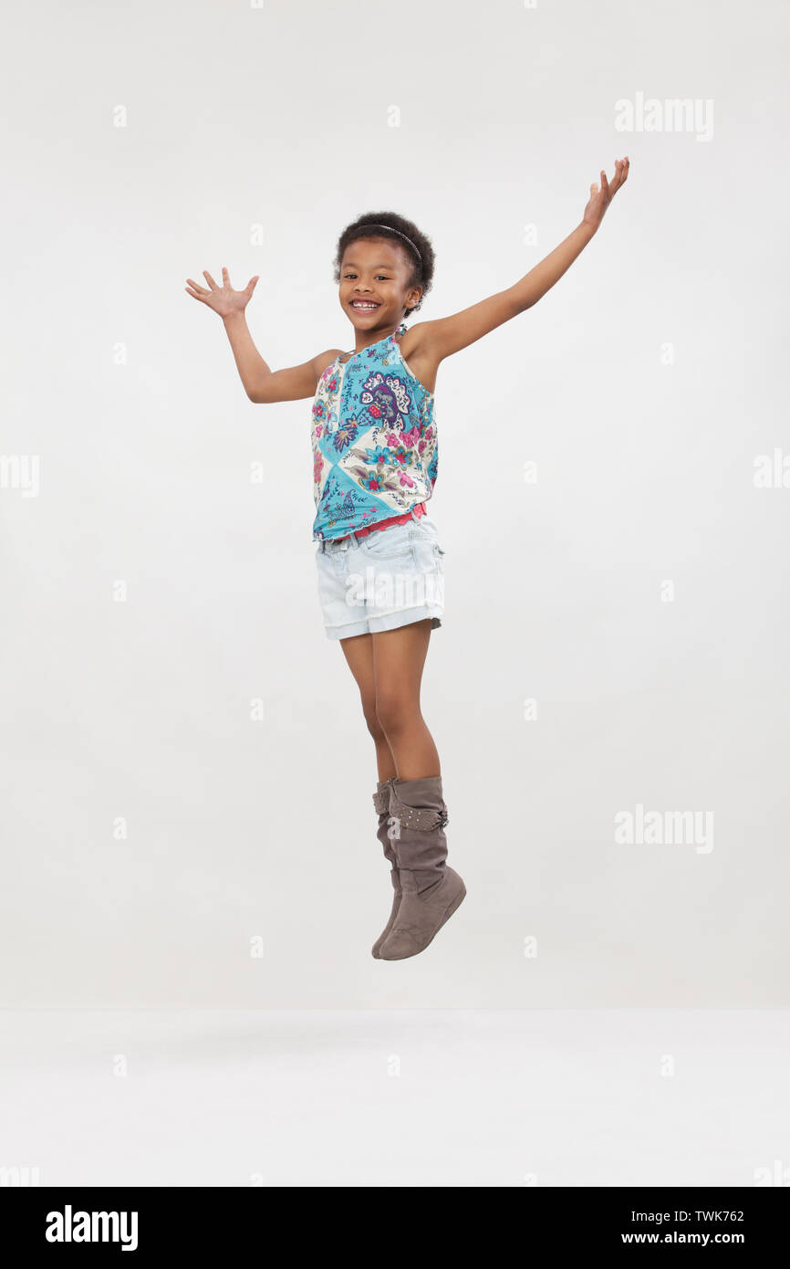 Girl jumping in air and smiling Stock Photo - Alamy