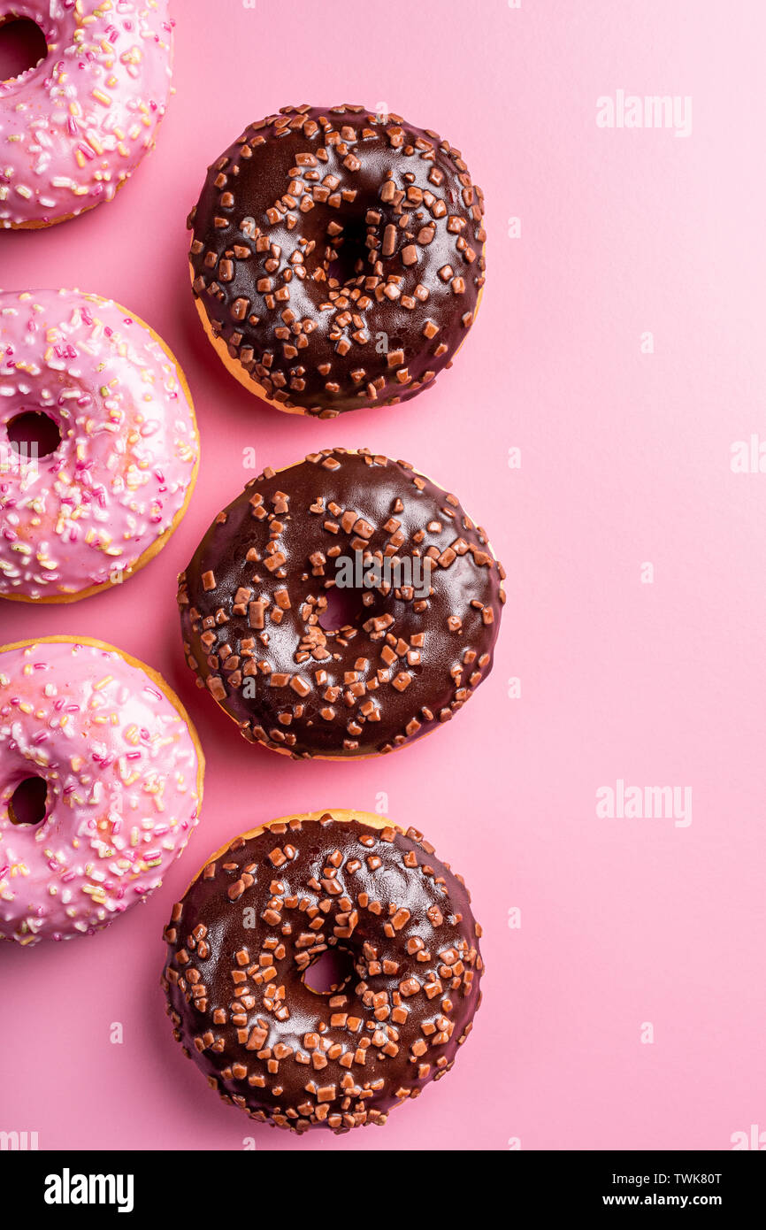 Colorful donuts on rose background Stock Photo - Alamy