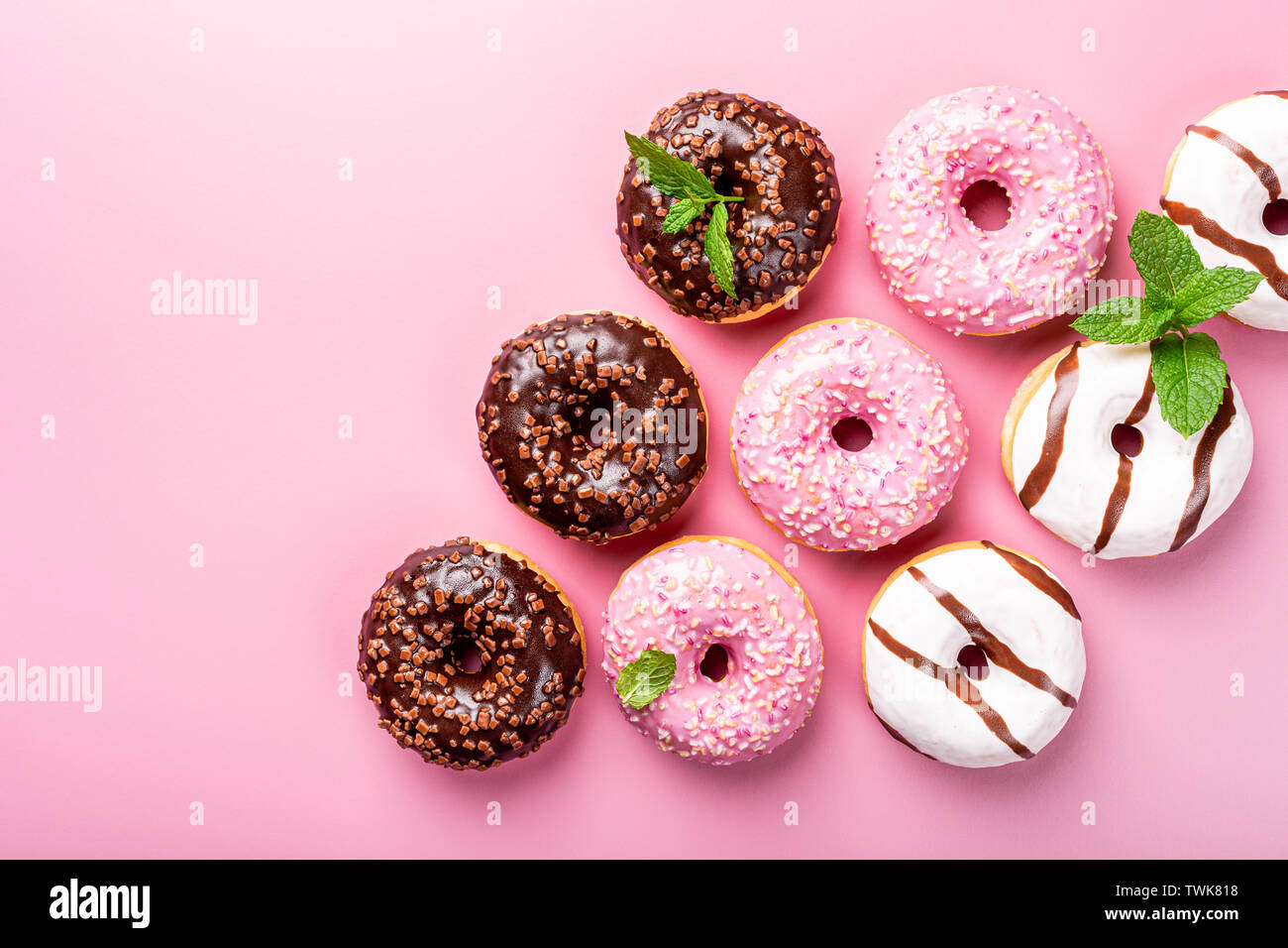 Colorful donuts on rose background Stock Photo - Alamy