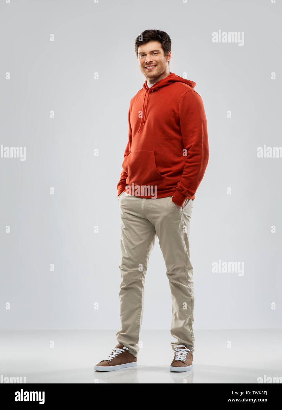 young man in red hoodie over grey background Stock Photo