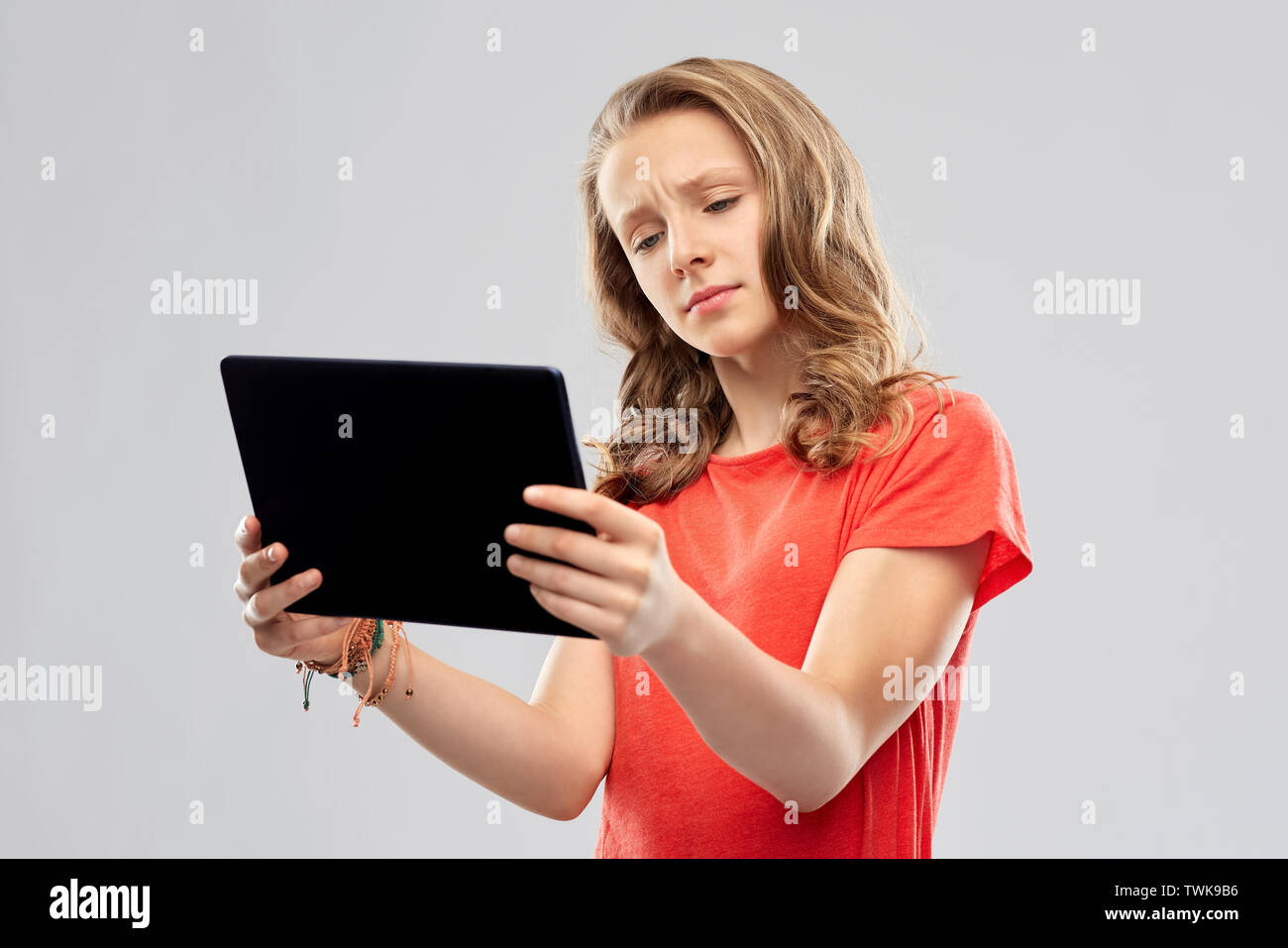 doubting teenage girl with tablet computer Stock Photo
