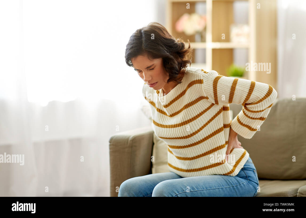Backache woman sofa hi-res stock photography and images - Alamy