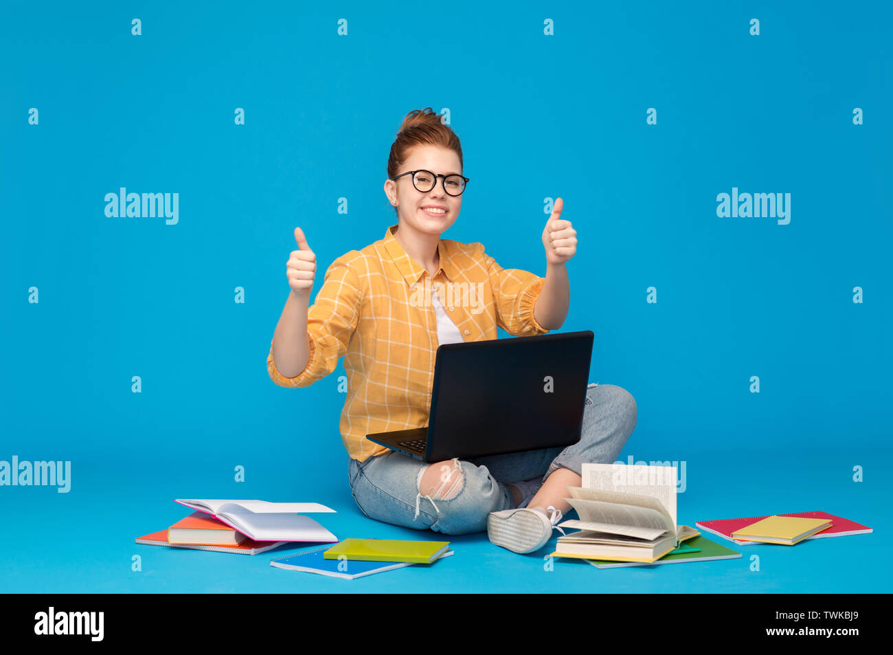 teenage student girl with laptop showing thumbs up Stock Photo - Alamy