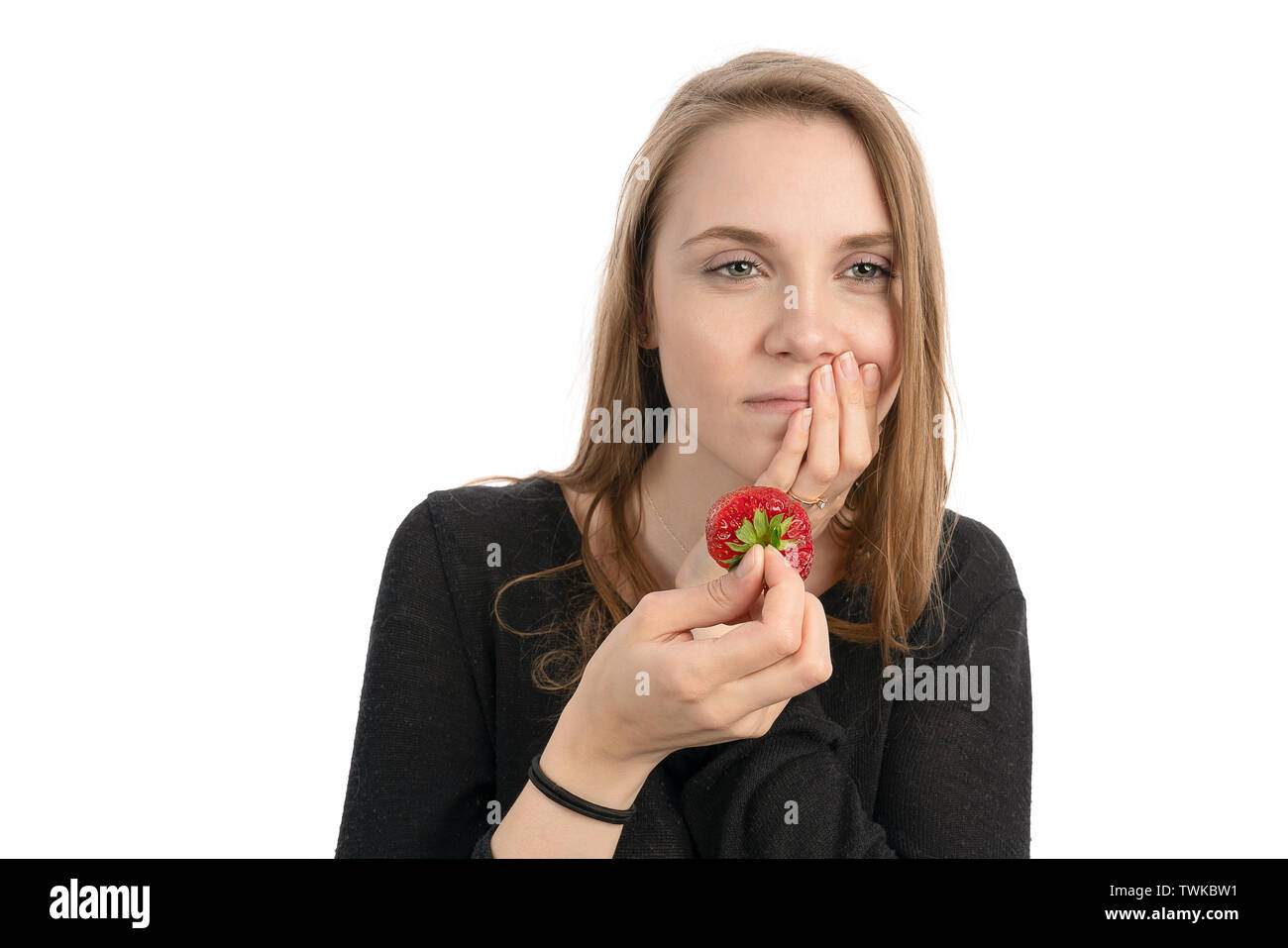 Young woman is pain sensitive when eating sweet strawberry Stock Photo