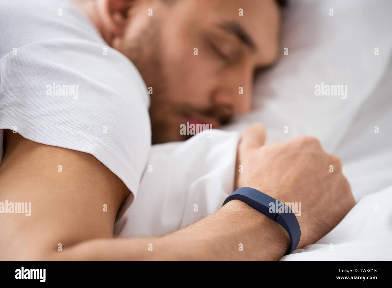close up of man sleeping with activity tracker Stock Photo