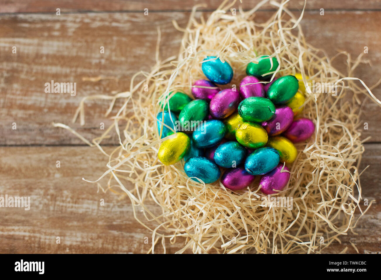 chocolate eggs in foil wrappers in straw nest Stock Photo Alamy