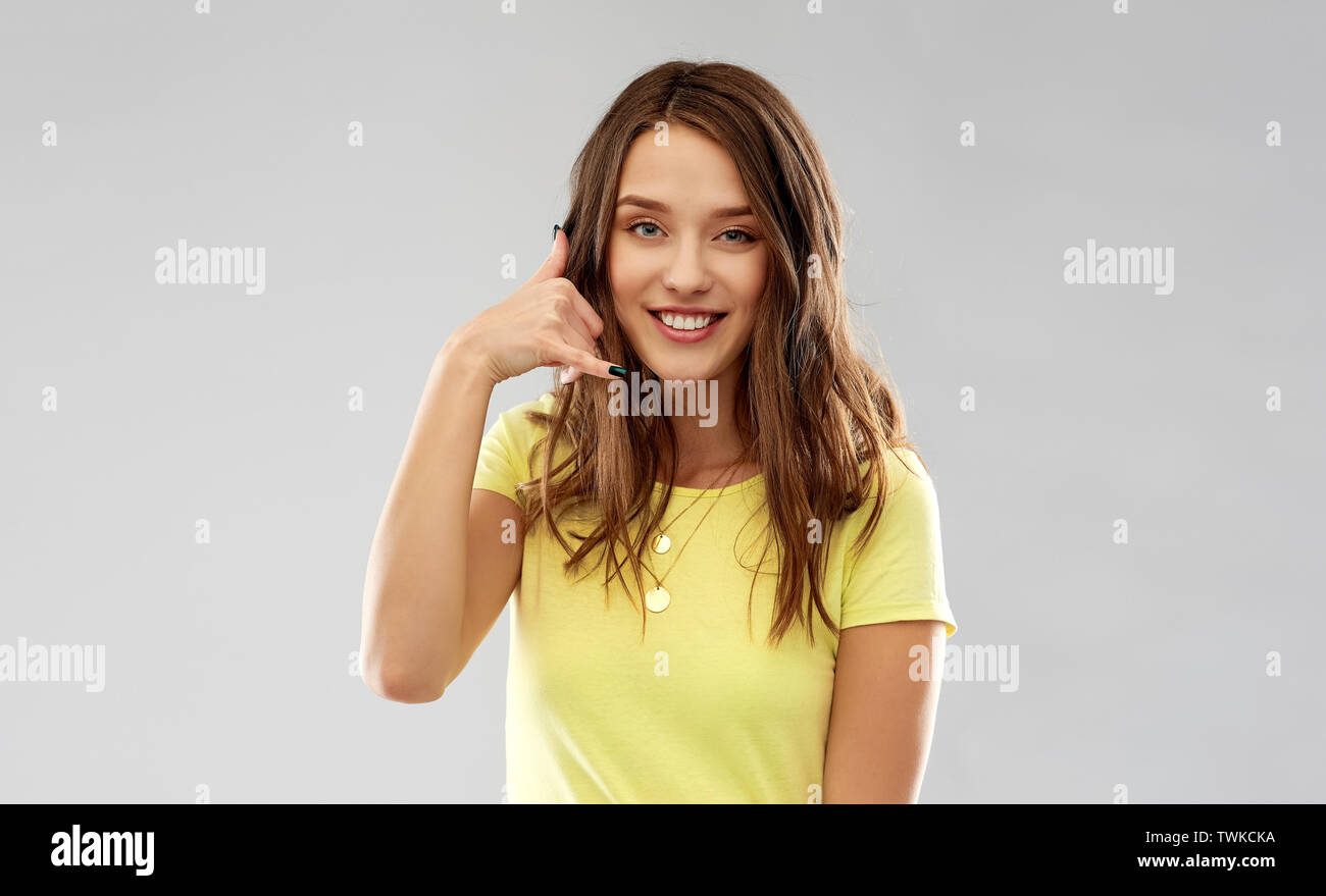 young woman or teenage girl showing call gesture Stock Photo
