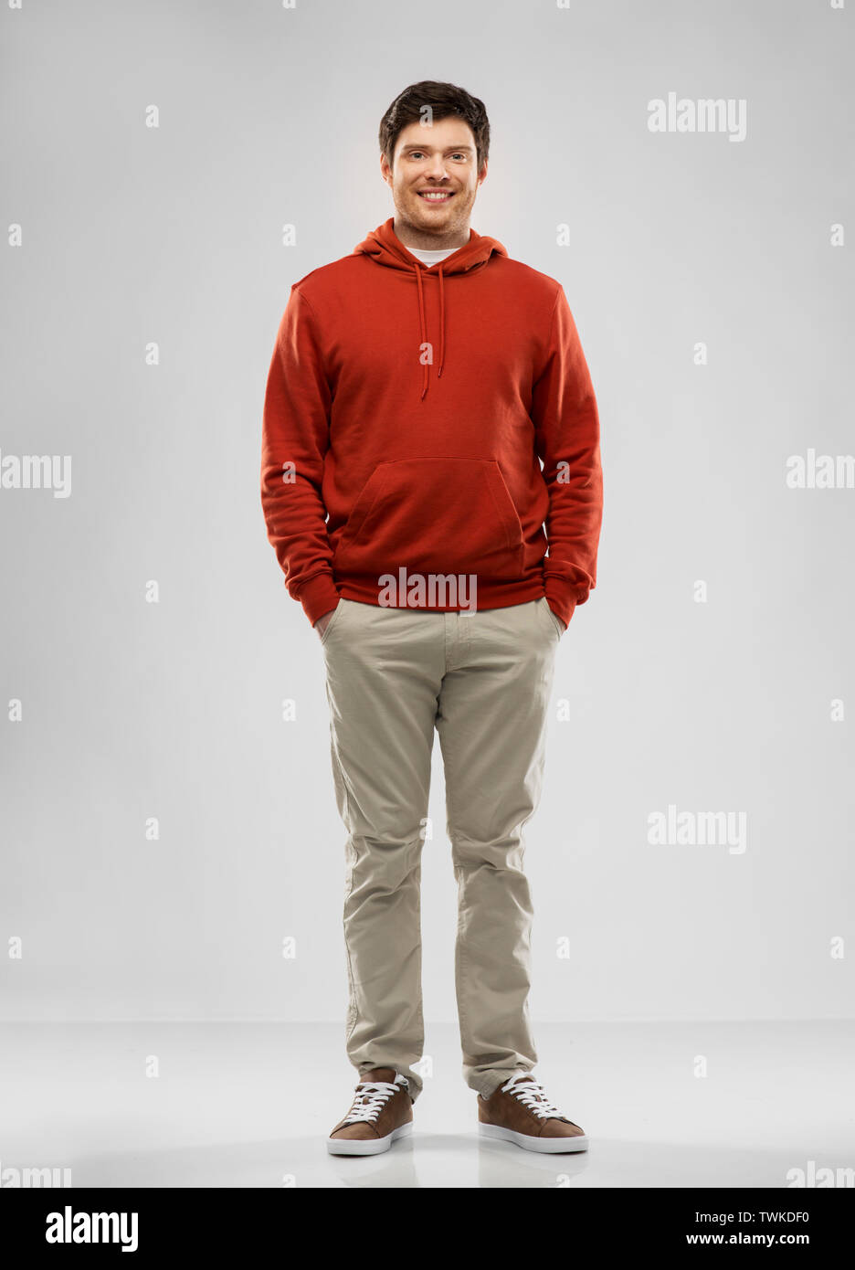 young man in red hoodie over grey background Stock Photo