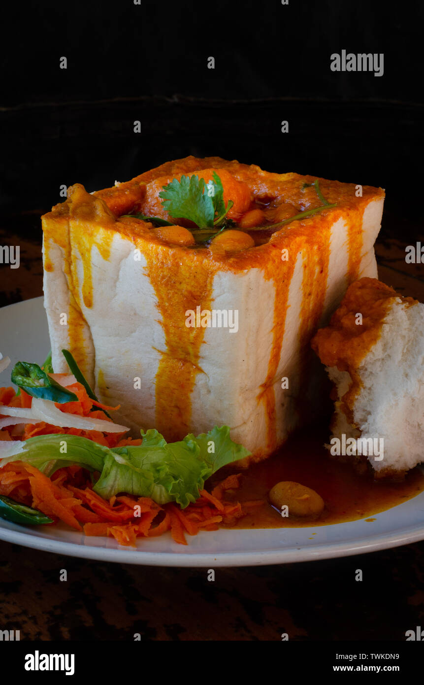 A Durban Bunny Chow or in this case a vegerarian quarter bean bunny served with sambals. The