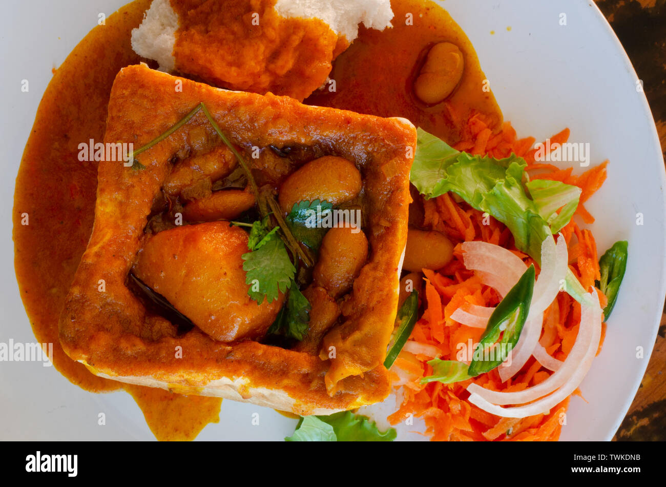 A Durban Bunny Chow or in this case a vegerarian quarter bean bunny served with sambals. The