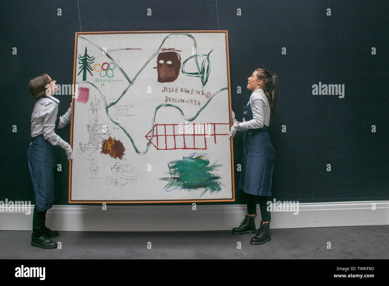 London, UK. 21st June, 2019. Sotheby's assistants with Big Snow, 1984, Acrylic and oilstick on canvas by Jean-Michel Basquiat. Estimate: £3,500,000-4,500,000 at the Sotheby's Contemporary Art Auction preview for the Evening sale on 26 June Credit: amer ghazzal/Alamy Live News Stock Photo
