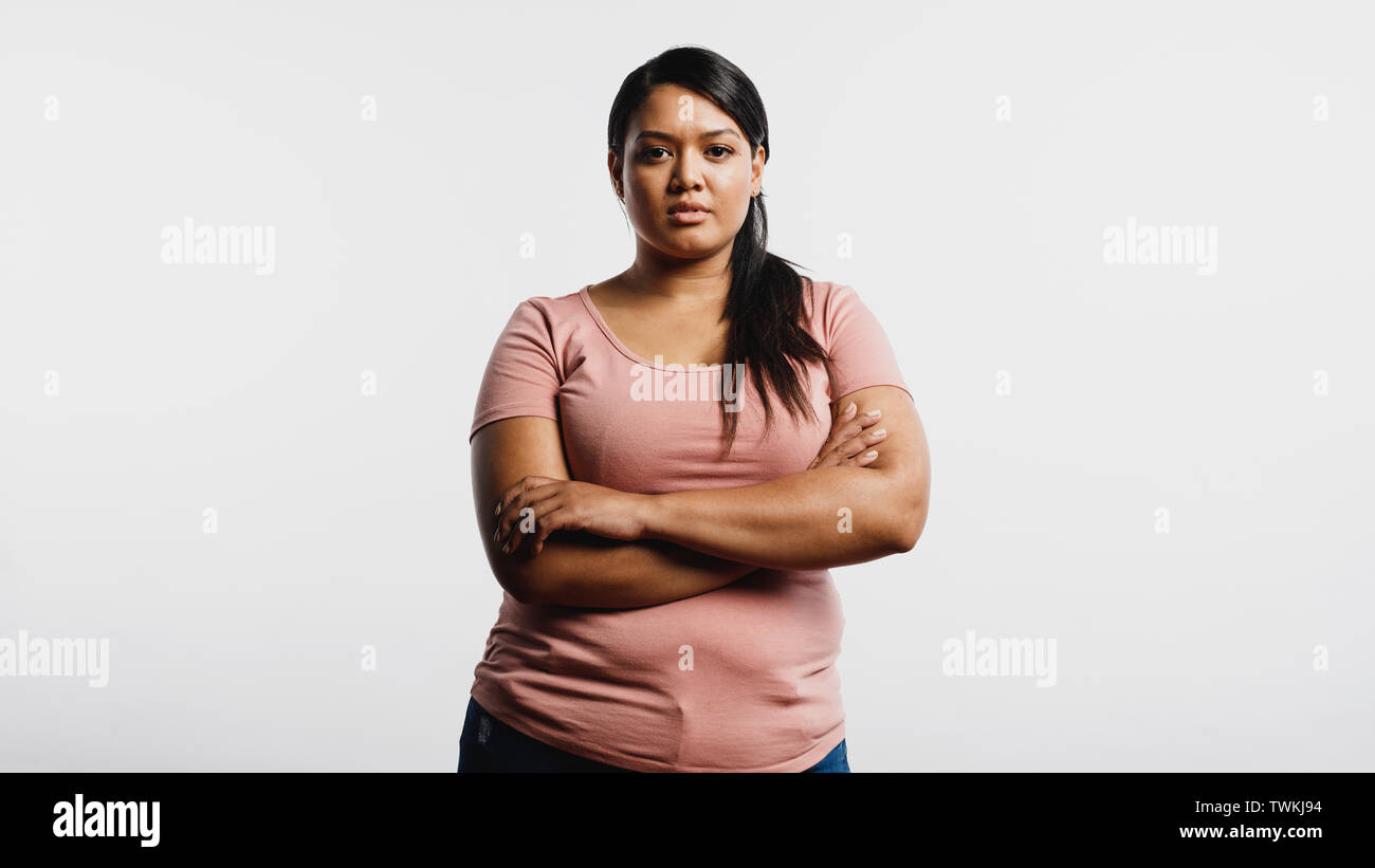 Woman with arms crossed standing against white background
