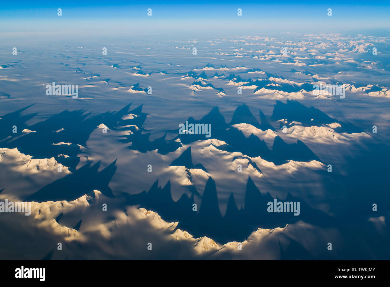Shadows cast by peaks in an aerial shot of mountains in Greenland Stock Photo