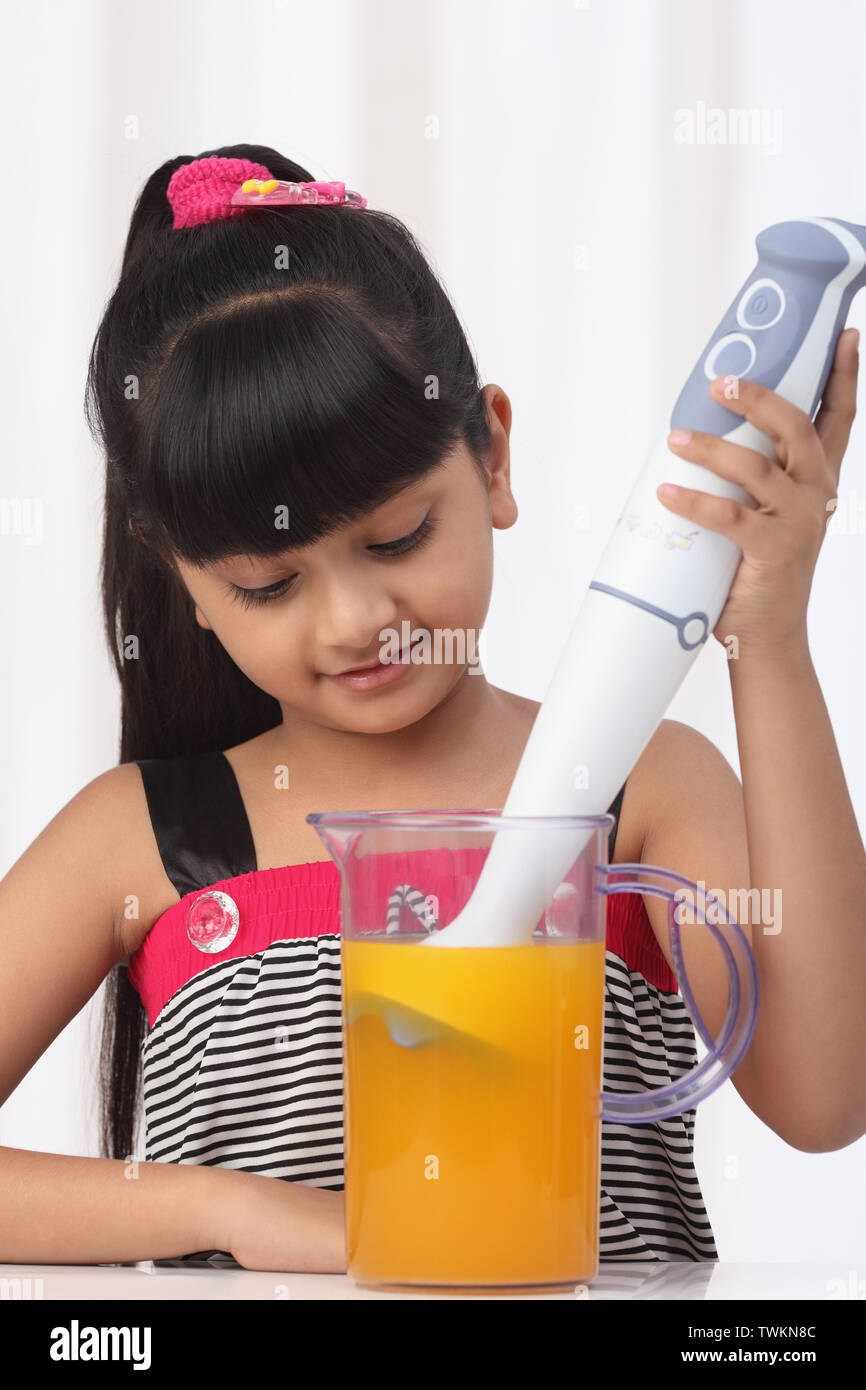 Girl making orange juice with blender Stock Photo Alamy