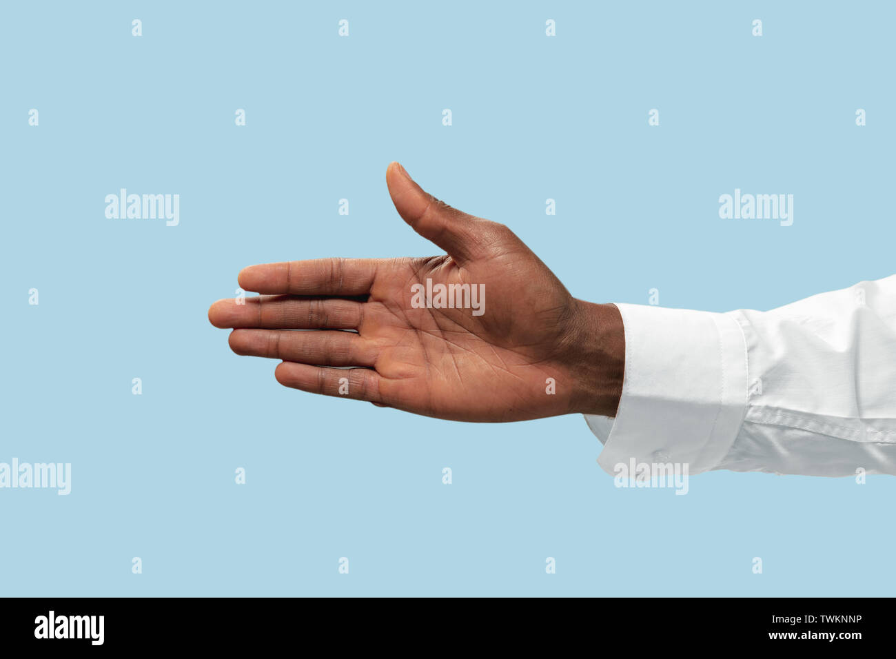 Male hand in white shirt demonstrating a gesture of inviting or pointing isolated on blue studio background. Concept of business, office, work. Negative space to insert your text or image. Stock Photo