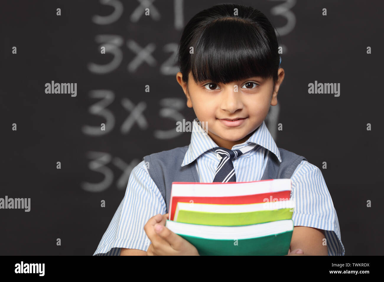 Girl holding pile of books classroom hi-res stock photography and ...