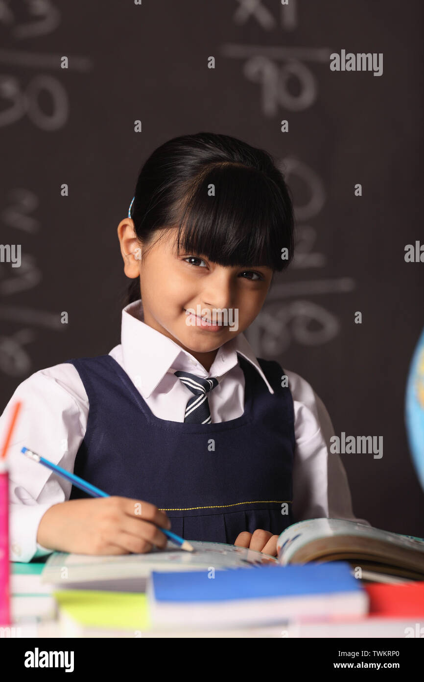 Portrait of a schoolgirl studying in a classroom Stock Photo - Alamy