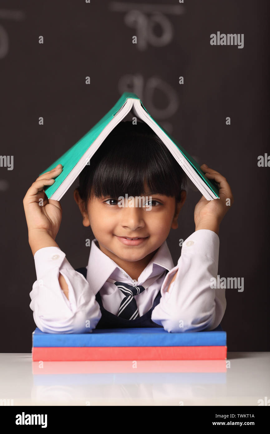 Schoolgirl holding an open book on her head Stock Photo - Alamy