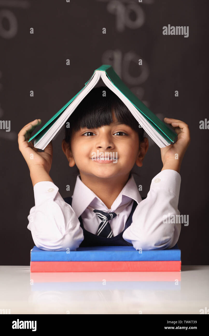 Schoolgirl holding an open book on her head Stock Photo - Alamy