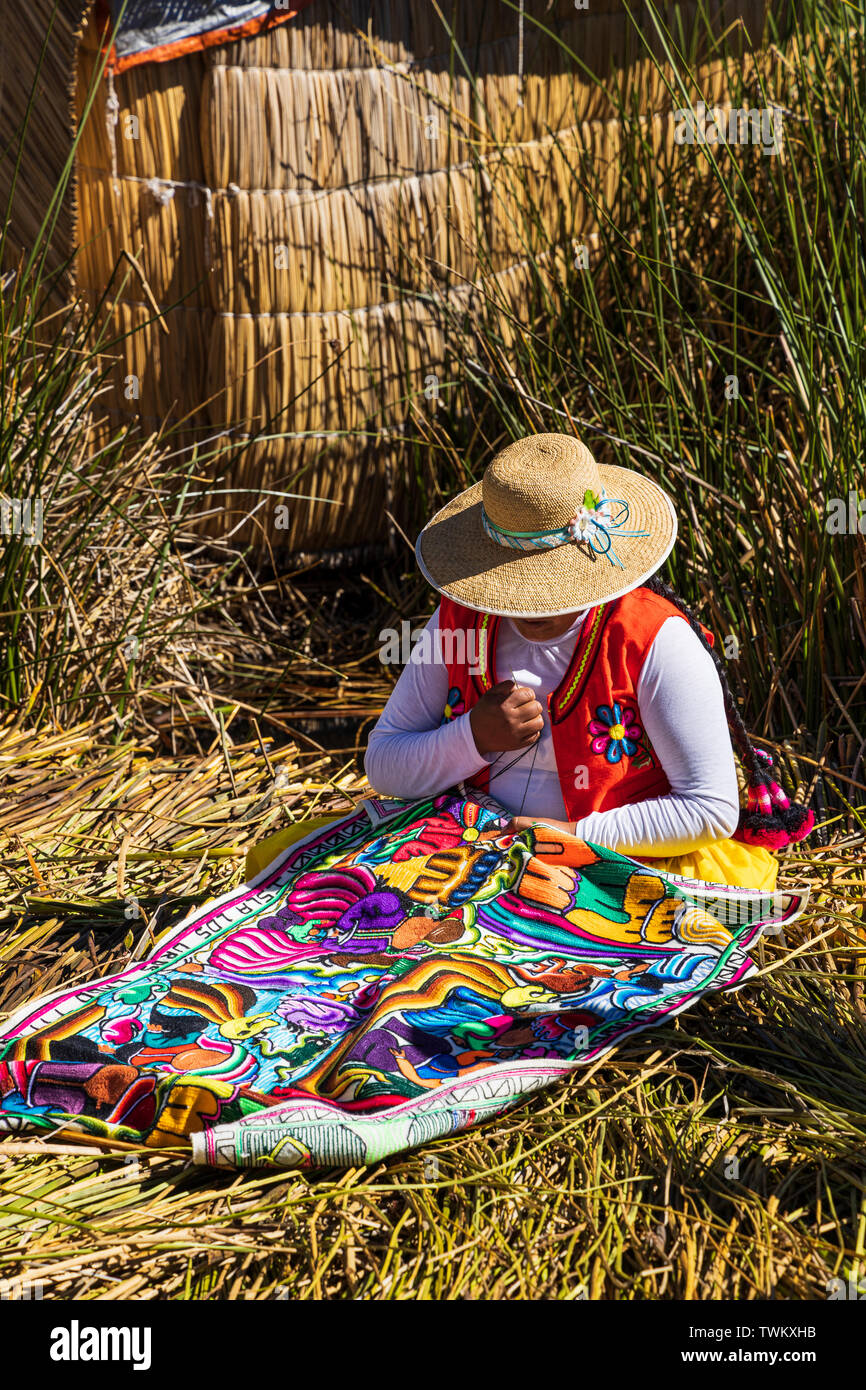 Woman stitching textiles on Uros islands, reed floating islands on Lake Titicaca, Peru, South America Stock Photo