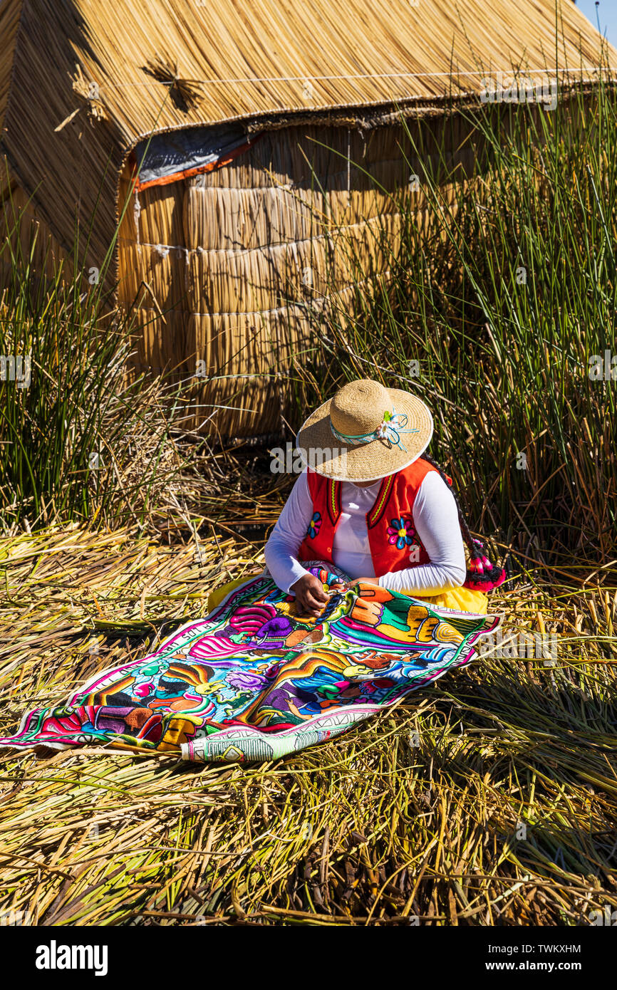 Woman stitching textiles on Uros islands, reed floating islands on Lake Titicaca, Peru, South America Stock Photo