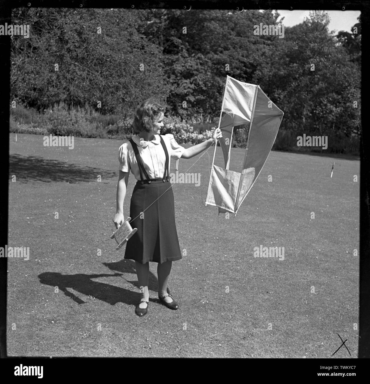 A teenage girl posing with a box kite on a croquet lawn c1948. Photo by Gilbert Adams    From The Gilbert Adams Collection of work owned by Tony Henshaw Stock Photo