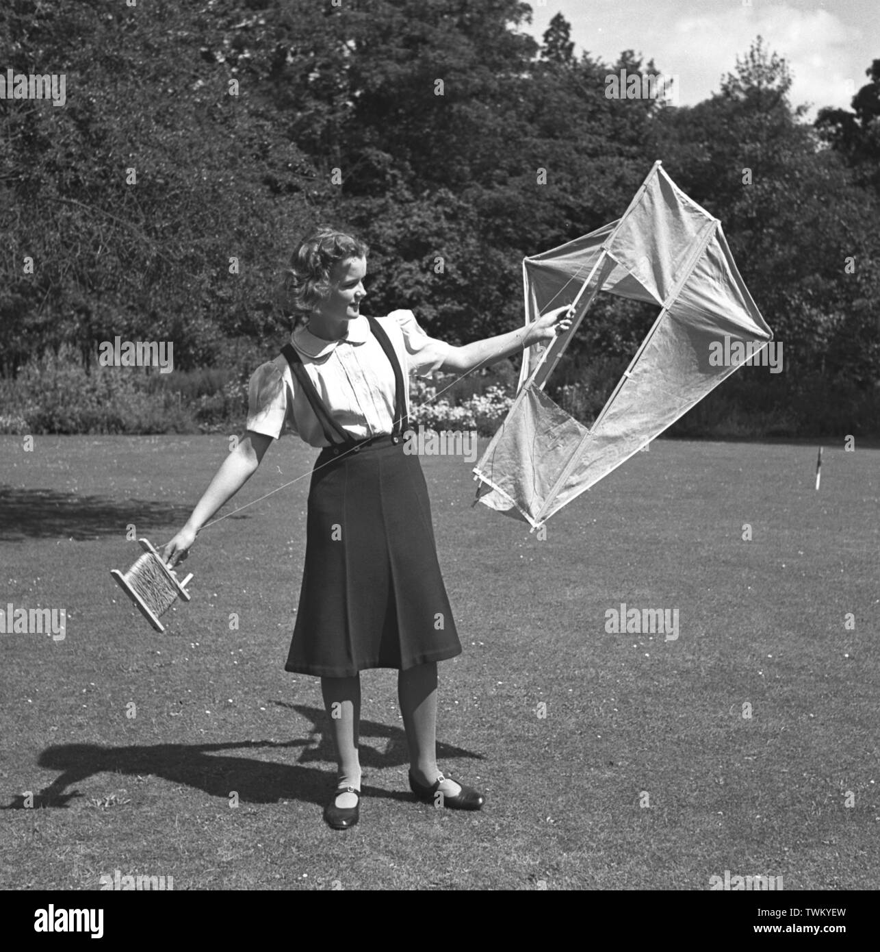 A teenage girl posing with a box kite on a croquet lawn c1948. Photo by Gilbert Adams    From The Gilbert Adams Collection of work owned by Tony Henshaw Stock Photo
