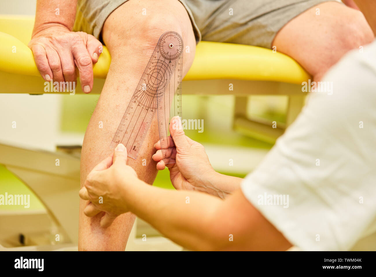Physiotherapist measuring the knee joint Mobility with the goniometer Stock Photo