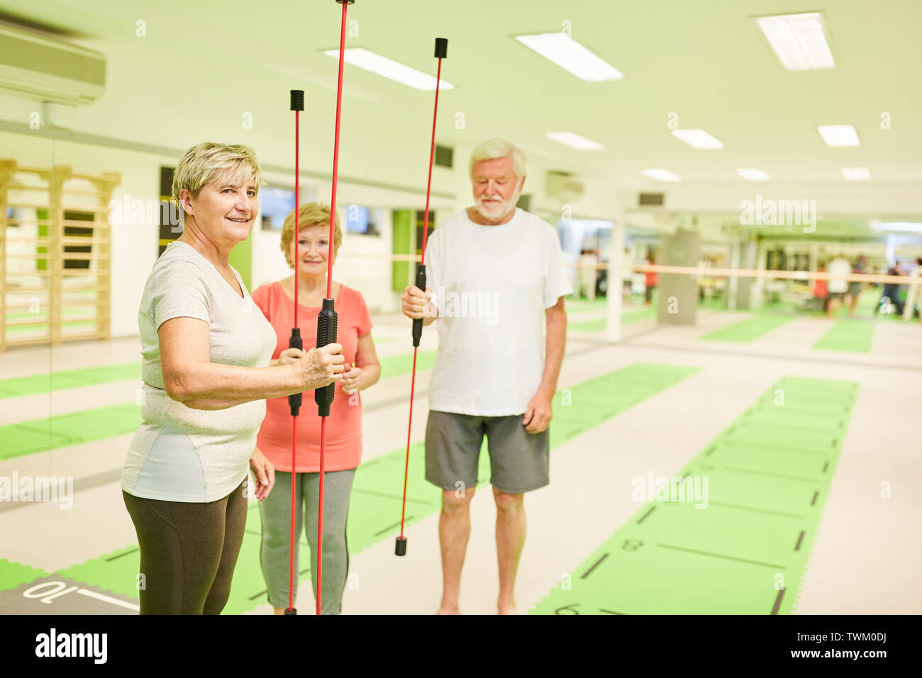 Senior group in fitness center with vibrating bar for deep muscle training Stock Photo