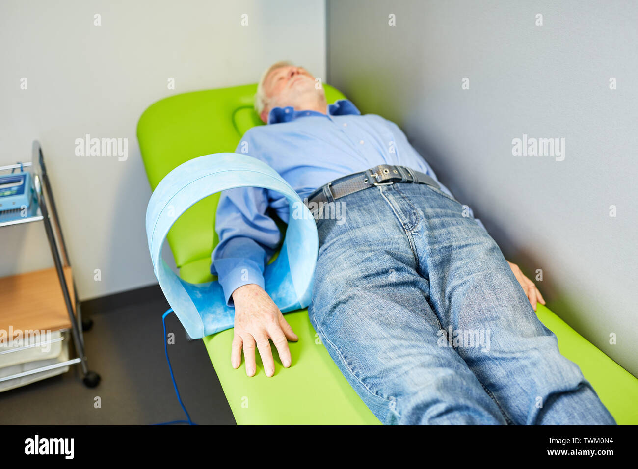 Senior as a patient gets a field therapy for the wrist as a