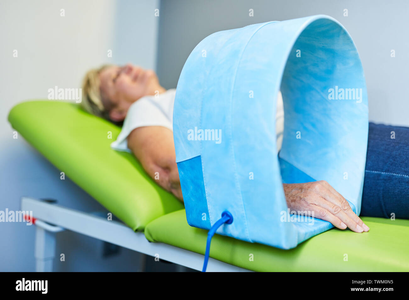 Senior gets Magnetic Therapy on the wrist as a naturopathy procedure at the Naturopath Stock Photo