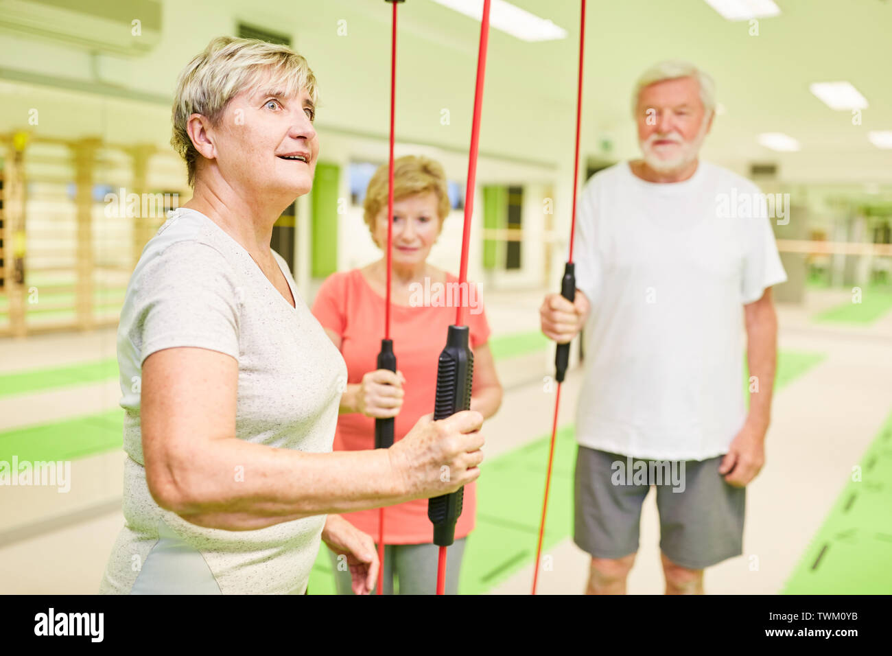 Group of seniors in the gym with the vibrating rod for deep muscle training Stock Photo