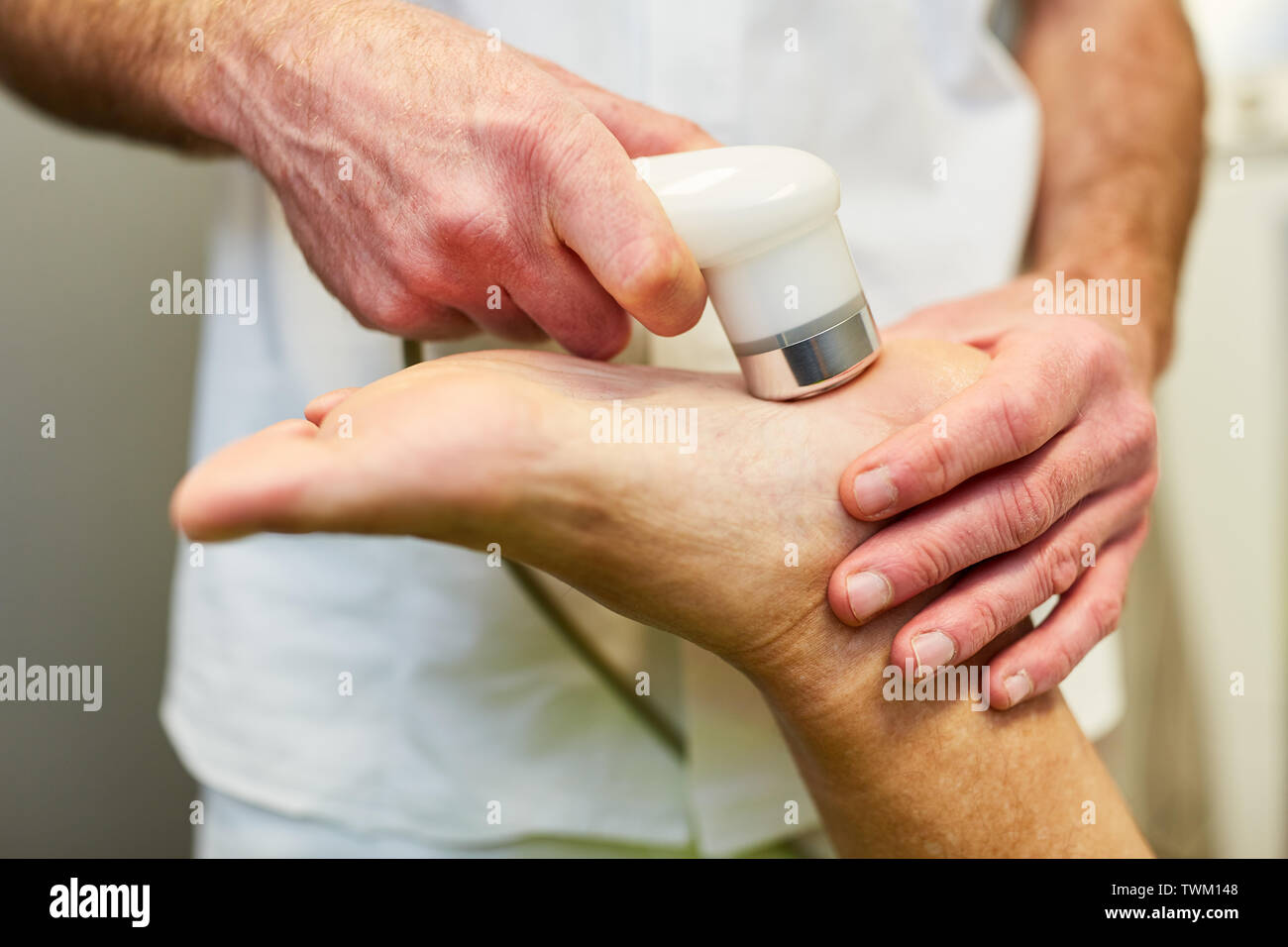 Doctor treats foot of patient with ultrasound as micro massage for pain  relief Stock Photo - Alamy