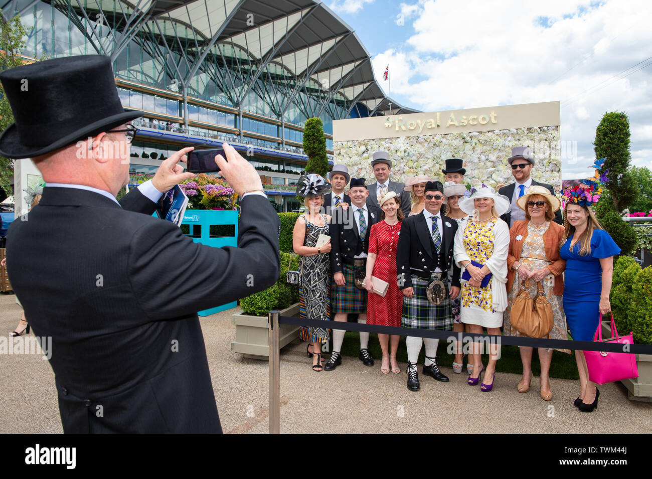 Ascot, Berkshire, UK. 21st June, 2019. A man in a top hat takes a photo ...