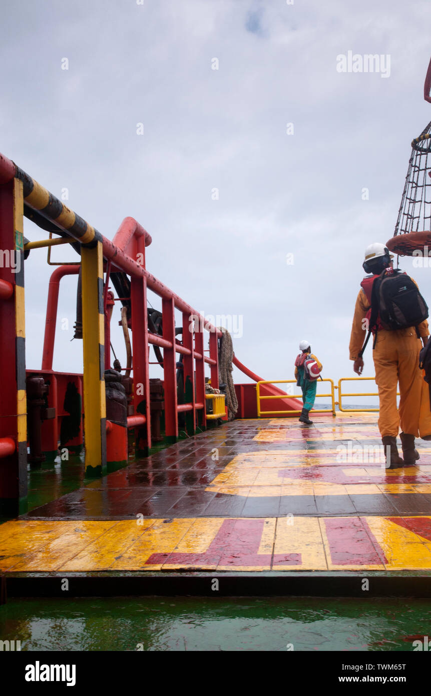 oil platform personal walking to safety basket before being transfer to oil platform Stock Photo