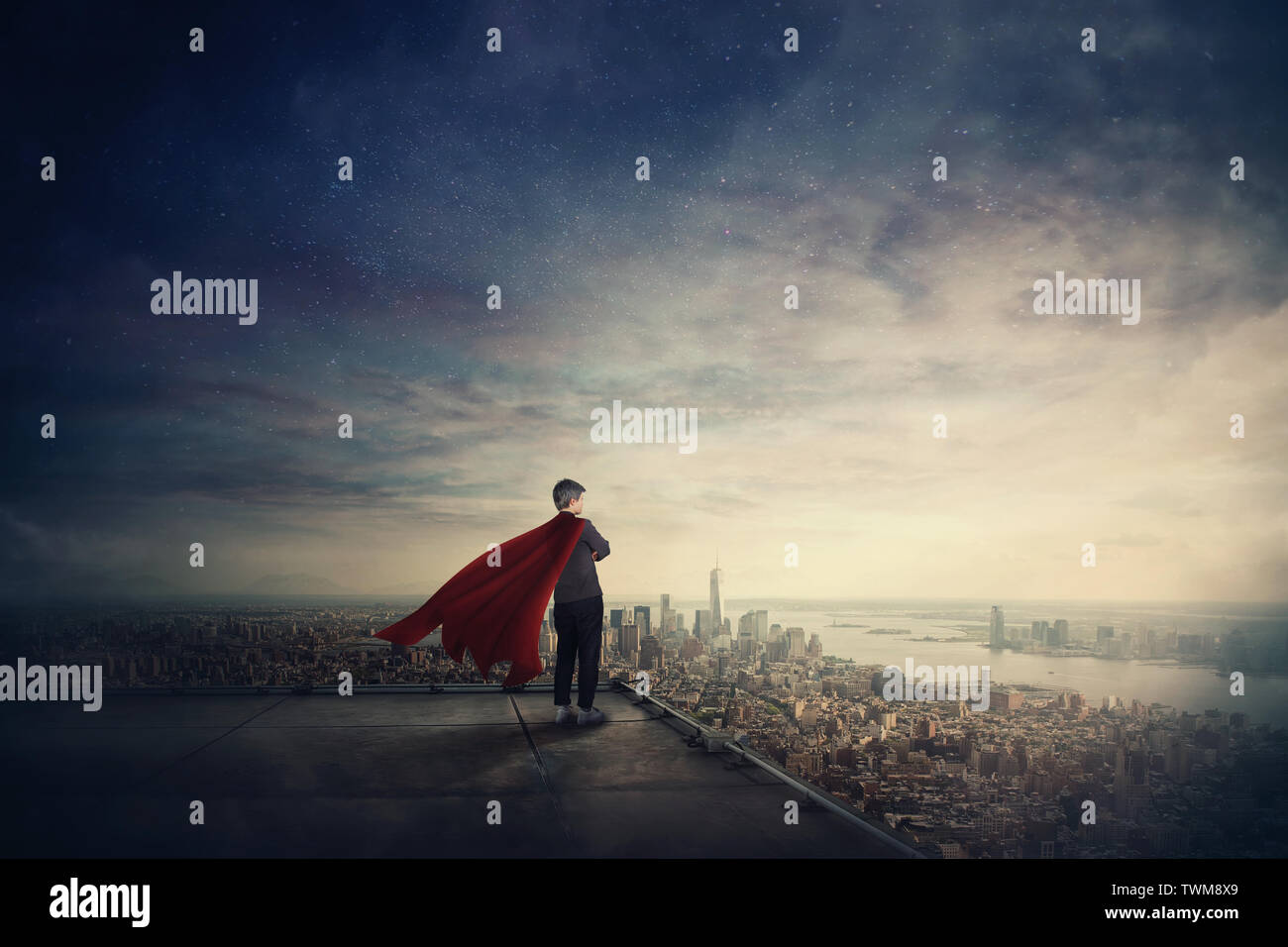 Businesswoman as confident superhero with red cape stands on the rooftop looking over city horizon. Ambition and business success concept. Leadership Stock Photo