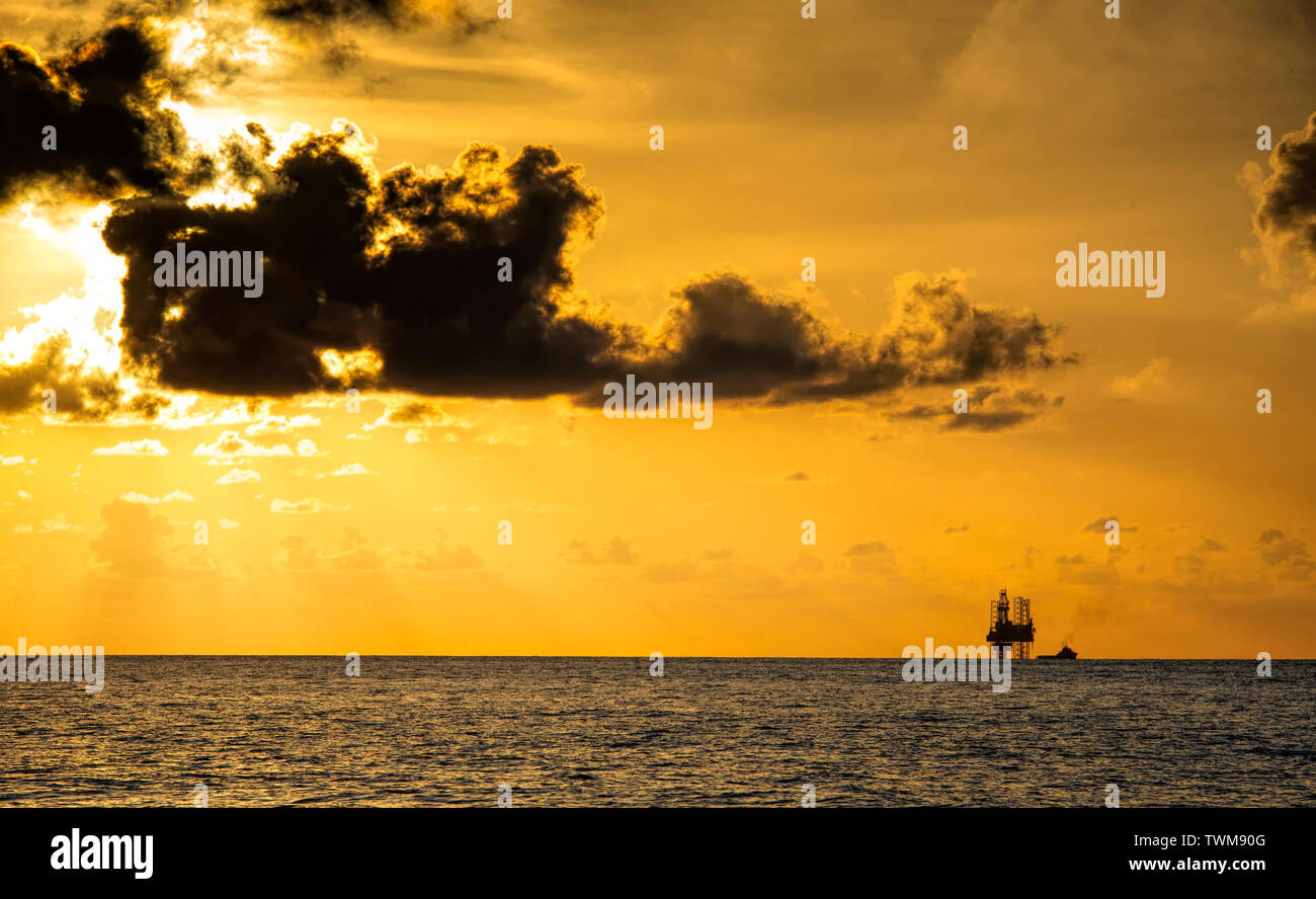 jack up rig and offshore supply boat with beautiful sunset at south china sea Stock Photo