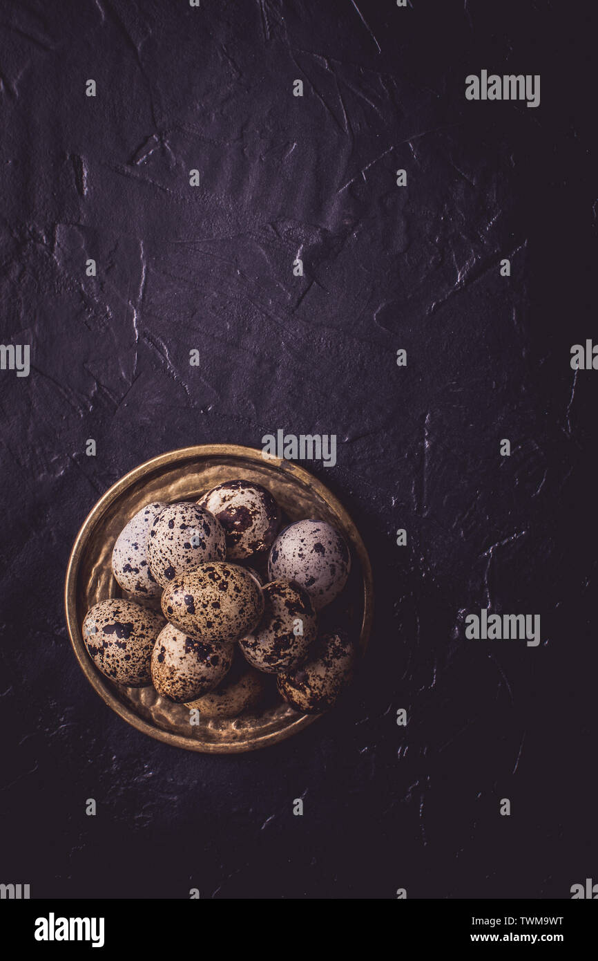 Small Quail Eggs on Dark Stone Background Stock Photo