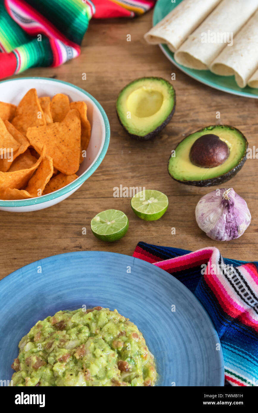 Mexican guacamole with ingredients close-up on the table Stock Photo