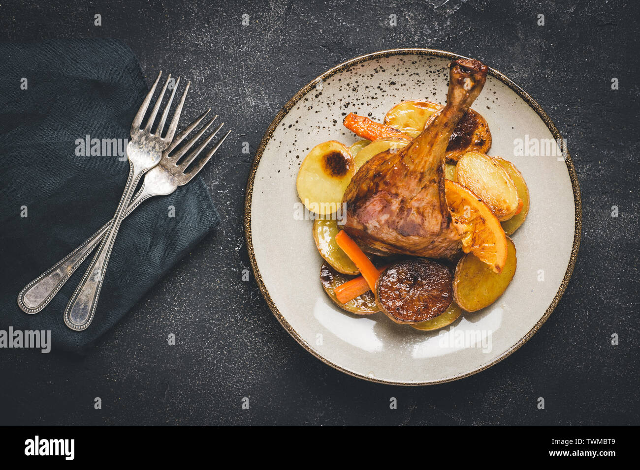 Roasted Chicken Leg Dish with Potatoes, Carrots and Oranges Stock Photo