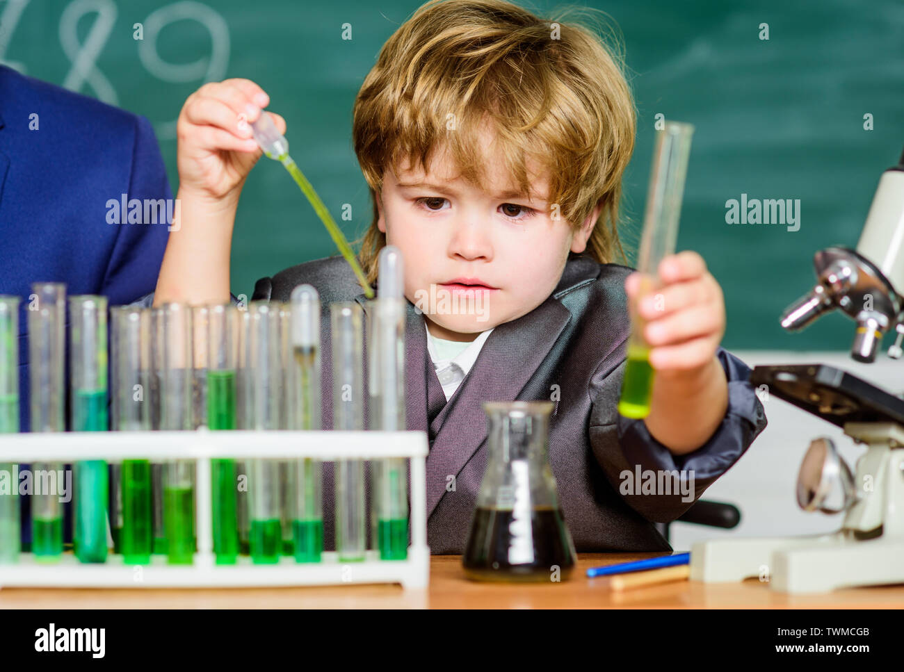 Pupil looking at testing tubes in the elementary school. kid in lab