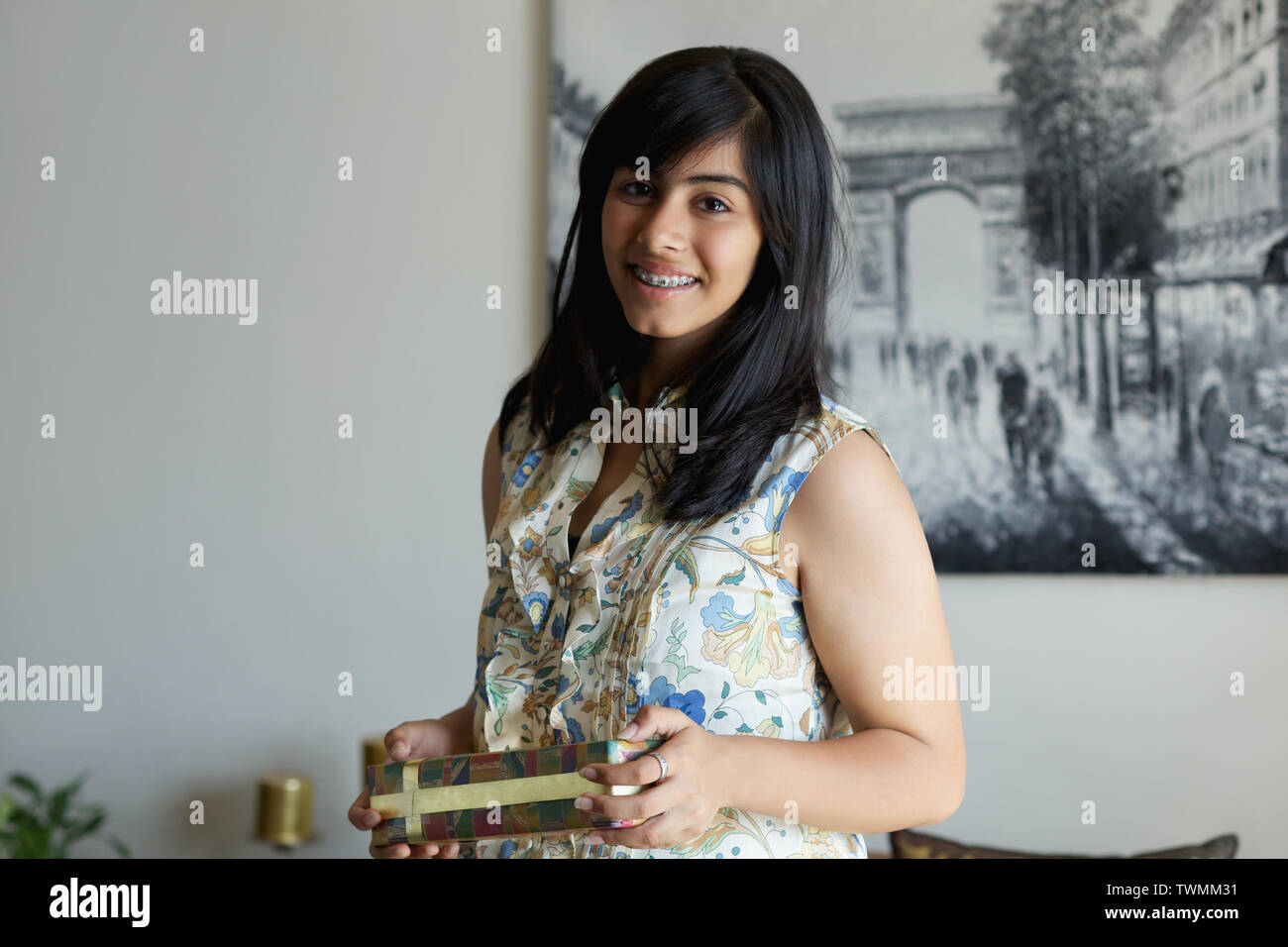 Portrait of a teenage girl holding a gift Stock Photo - Alamy