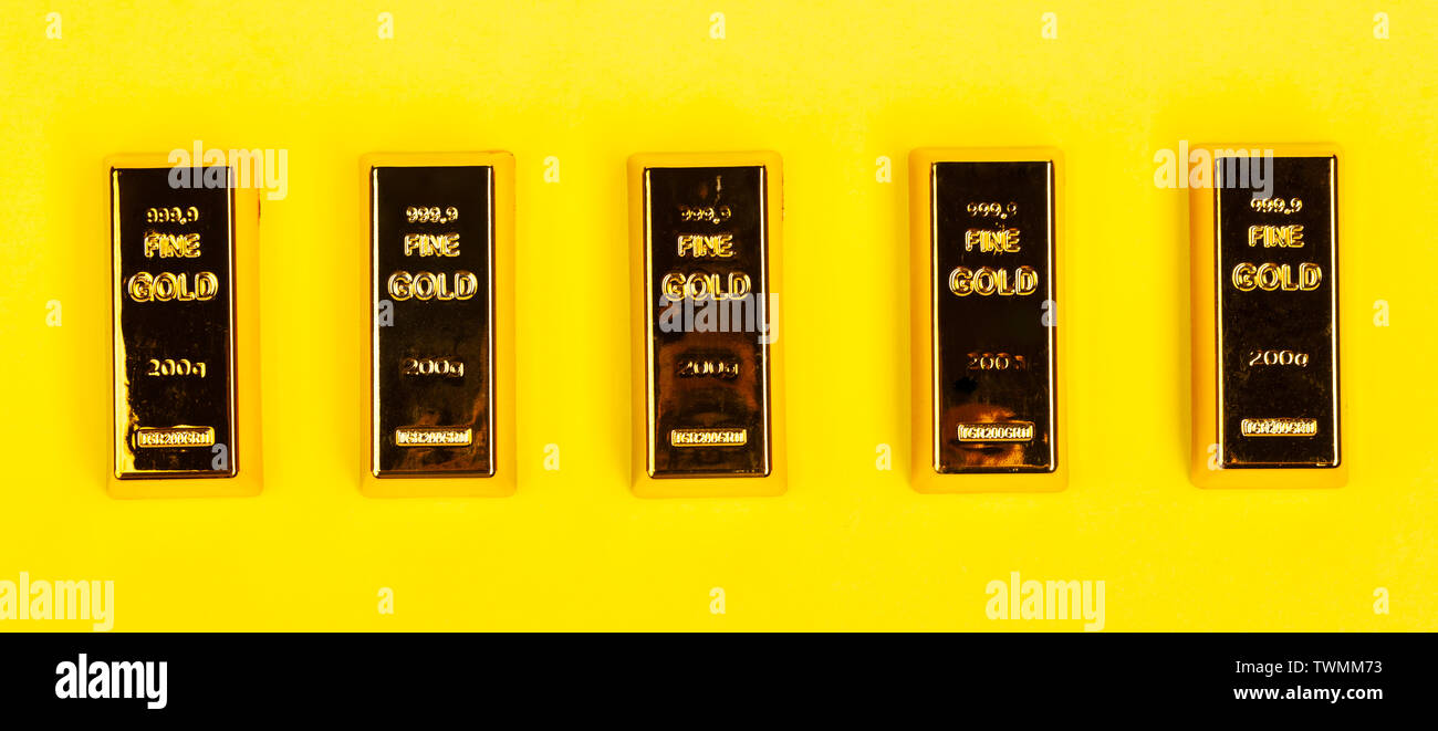 Bars of gold bullion on yellow background. Financial concept. Stock Photo