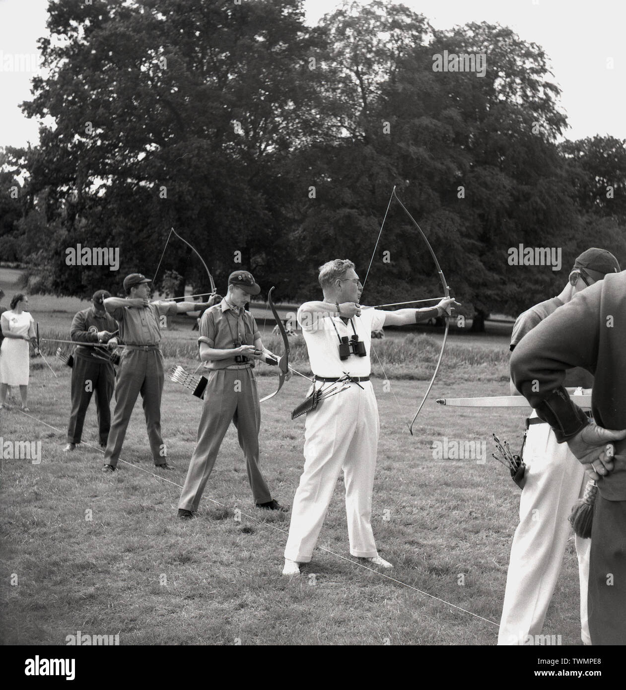 1960s, historical, outdoor archery competition, males and archers and a female archer line-up in a field with their bows and arrrows taking aim, England, UK. Stock Photo