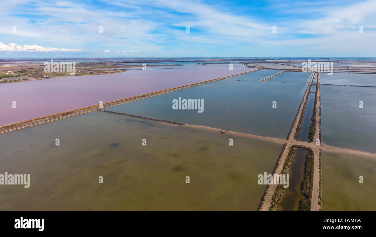 Square pool for evaporation of salt and a pond with pink water. Aerial view. Stock Photo