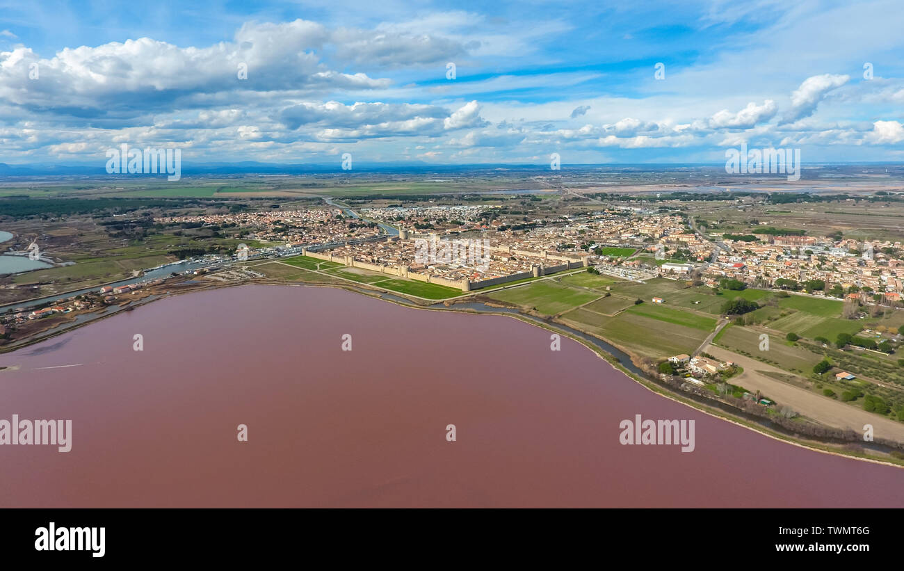 Aerial view on the pink salt lake and Aigues-Mortes - the town behind the stone fortification wall. Stock Photo